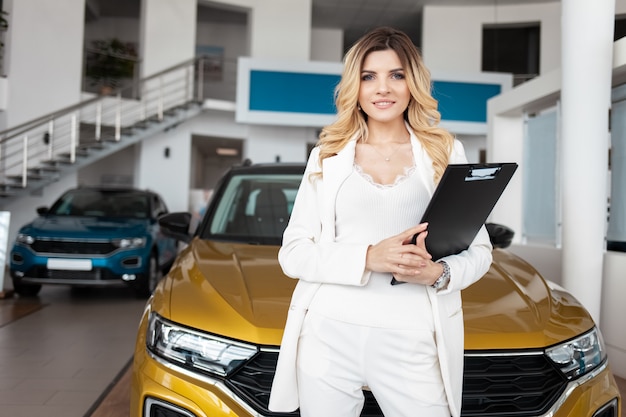 De agent van de autoverkoopvrouw bij een autodealer