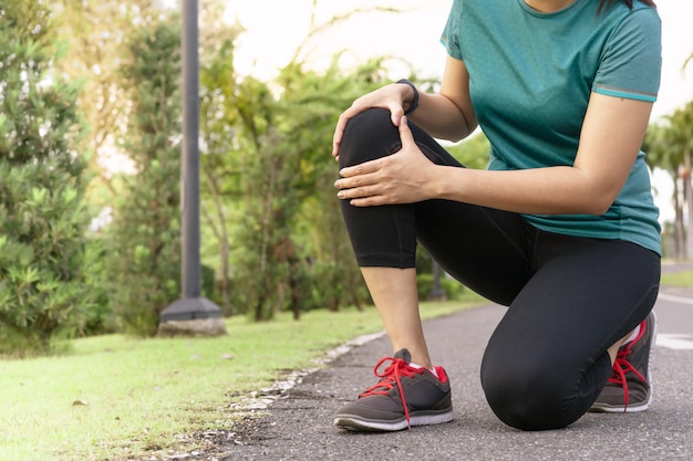 De agent van de geschiktheidsvrouw voelt pijn op knie. Outdoor oefening activiteiten concept