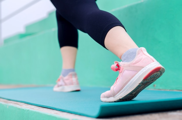 De agentvoeten die van de vrouw aan het lopen op trap in gymnastiek uitoefenen, zij jogging, geschiktheid