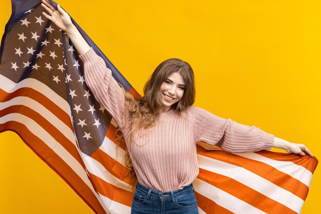 De Amerikaanse vlag en de schoonheid van de vrouw komen prachtig samen in deze foto die afsteekt tegen de gedurfde gele achtergrond en een blijvende indruk achterlaat