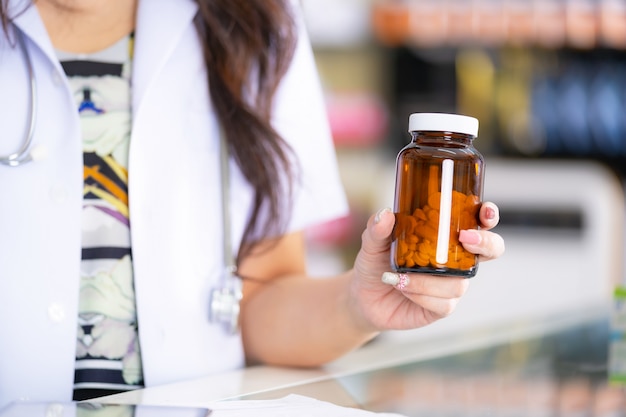 De apotheker heeft een fles medicijnen in de apotheek