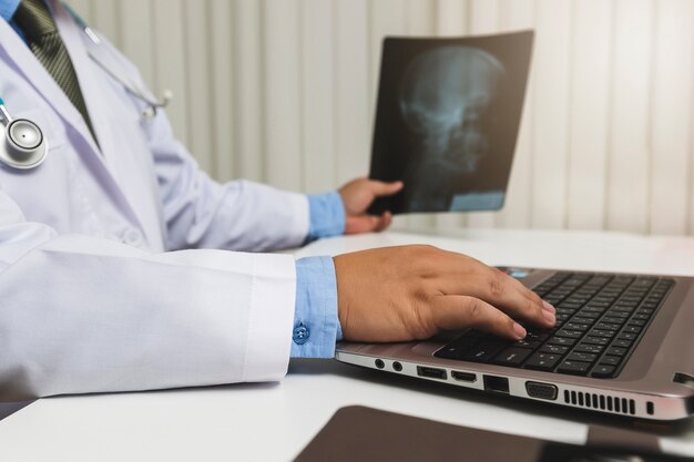 De arts diagnostiseert en analyseert op röntgenstraalfilm van patiënt.