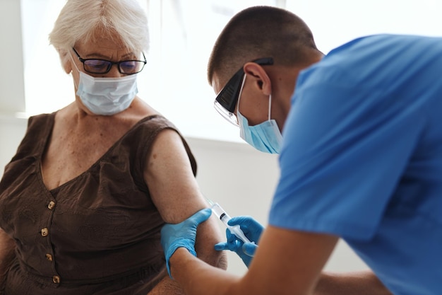 Foto de arts injecteert het vaccin in het patiëntenziekenhuis covid19