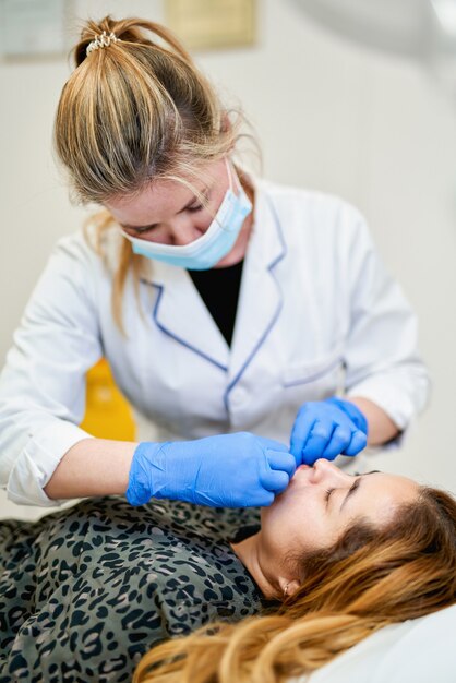 De arts-schoonheidsspecialist maakt Lipvergroting procedure van een mooie vrouw in een schoonheidssalon