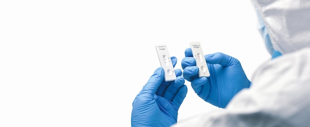 Foto de arts vergelijkt tape van een snelle antigeentestkit voor een covid-19-resultaat, horizontale kopieerruimte op witte achtergrond