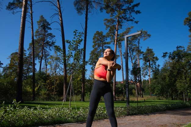 De atleet doet een warming-up terwijl hij midden in een stadspark staat. Buitensport.