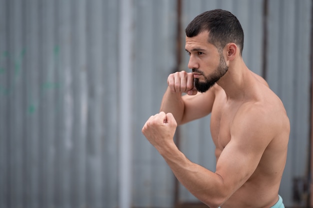 Foto de atleet vecht met de schaduw. een bokser traint stoten op straat