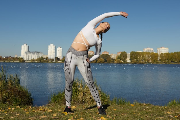 De atleet warmt zich op voor een hardlooptraining in het park Heerlijk weer om te joggen in het stadspark