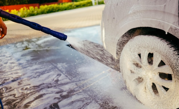 De auto inschuimen met het schuim Carwash Man auto wassen op de zelfwasservice Hoge druk