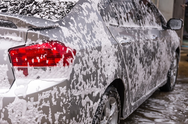 De auto schoonmaken met schuim, wasstraat