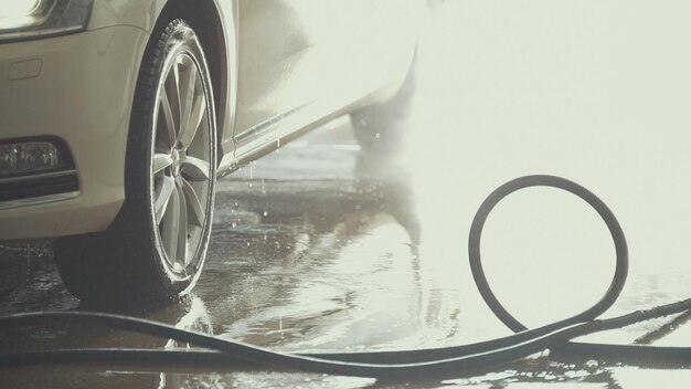 De auto staat onder het water na het wassen van de auto