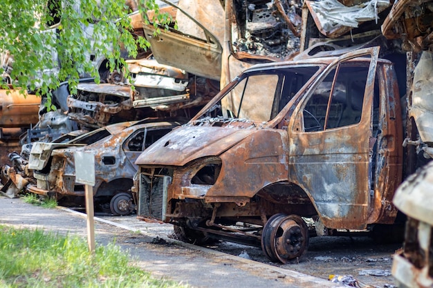 De auto werd volledig verwoest door brand verlaten verbrande en roestige auto langs de weg auto's stonden in brand op de parkeerplaats oorlog van rusland tegen oekraïne granaatscherven en kogelgaten in auto's