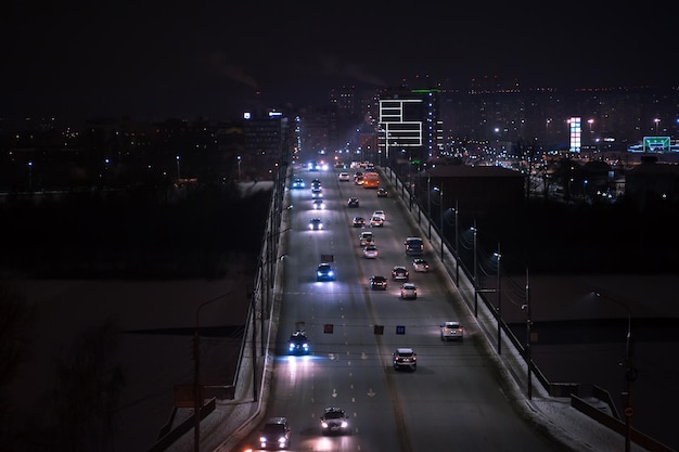De autolichtsporen op de snelweg in de moderne nachtstad