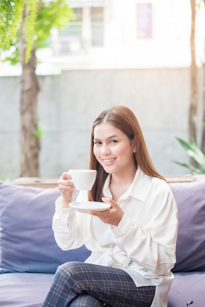 De Aziatische Bedrijfsvrouw drinkt koffie in de ochtend bij koffiewinkel