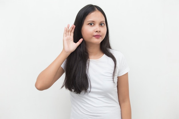 De Aziatische bedrijfsvrouw houdt haar hand dichtbij haar oor en luistert