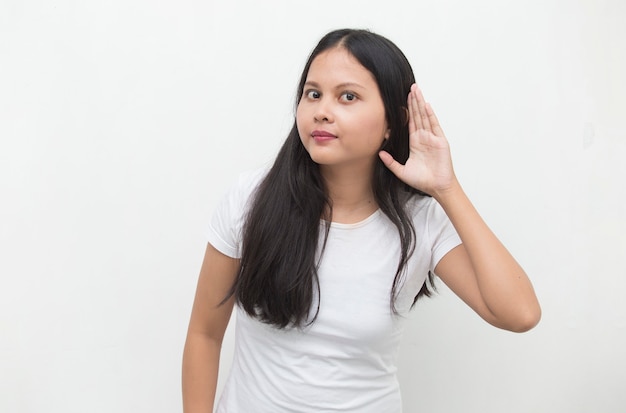 De Aziatische bedrijfsvrouw houdt haar hand dichtbij haar oor en luistert