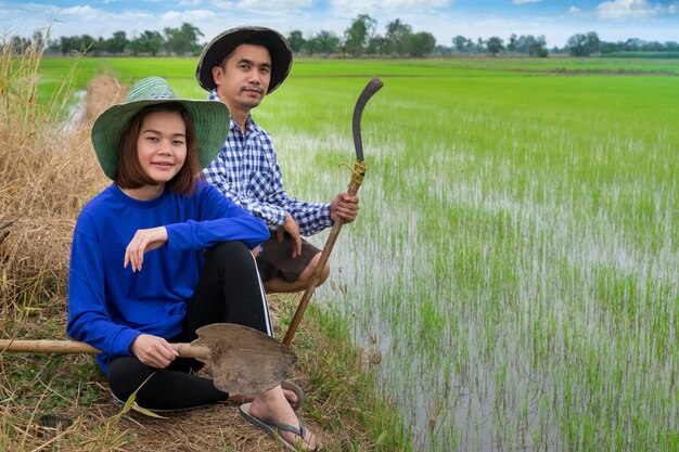 De Aziatische Landbouwers koppelen holdingshulpmiddelen die in rijstlandbouwbedrijf zitten in Thailand