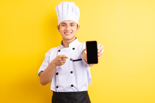 De Aziatische mannelijke chef wees met zijn vinger naar de mobiele telefoon die hij vasthield