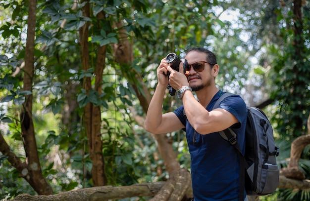 De Aziatische mensenrugzakken en reiziger die samen en gelukkig lopen nemen foto op bos, ontspannen tijd op de reis van het vakantieconcept