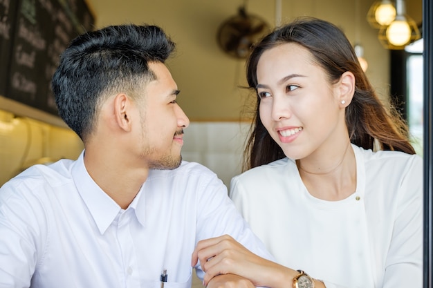 De Aziatische Minnaarman en de vrouw genieten van met een kop van koffie in koffiewinkel.