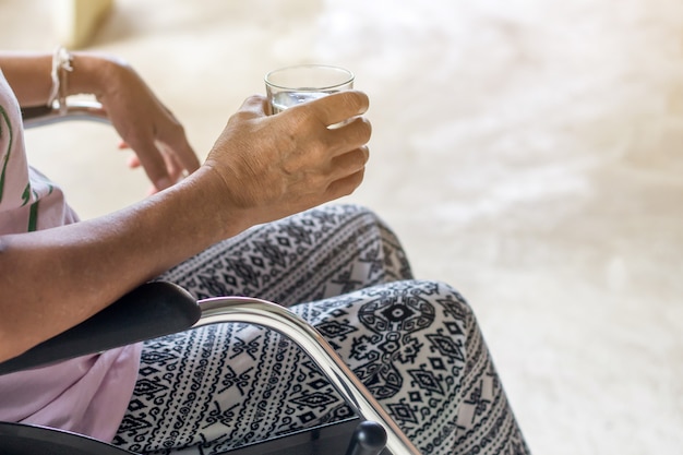 De Aziatische oudste of bejaarde oude patiënt van de damevrouw op thuis zo droevige rolstoel, gezond sterk medisch concept