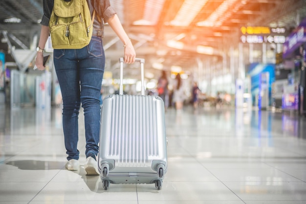 De Aziatische vrouw die van de schoonheid en koffer in de luchthaven reist houdt. Mensen en levensstijlen co