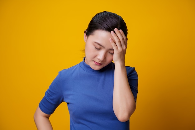 De Aziatische vrouw had hoofdpijn en raakte haar hoofd op geel aan.