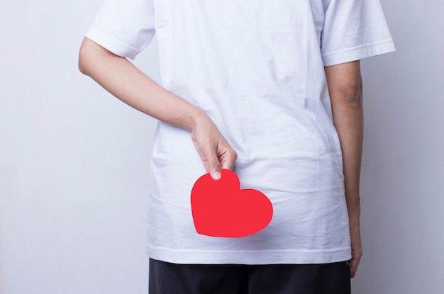 De Aziatische vrouw in witte kleding toont hartvorm in het concept liefde en valentijnskaart