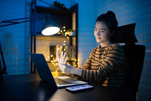 De aziatische vrouw was ziek met lichaamspijn die thuis overuren aan laptop werkte. . werk vanuit huis om het coronavirus covid 19-concept te vermijden.