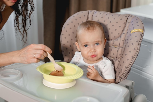 De baby eet tot een jaar aan de kindertafel