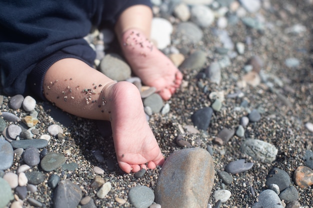 De baby kruipt op het kiezelstrand