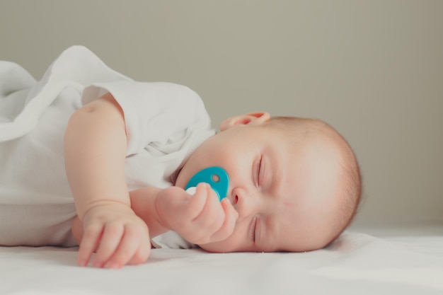 De baby ligt in zijn wieg en kijkt naar de camera Een blij kind Kinderartikel