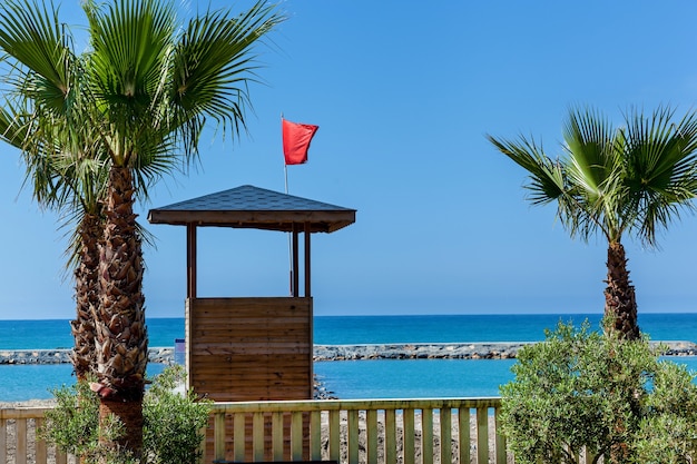 De badplaats met een prachtig uitzicht op de blauwe zee De badmeestertoren met rode vlag