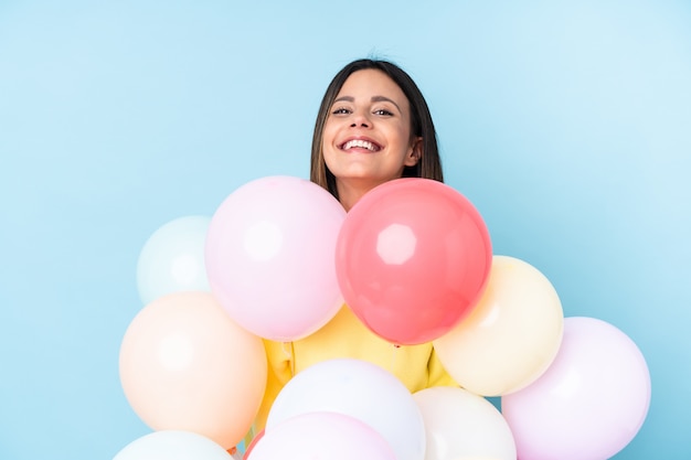 De ballons van de vrouwenholding in een partij over blauwe muur