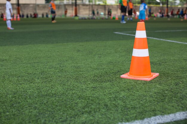 De baltactiek van het jongensvoetbal op grasgebied met kegel