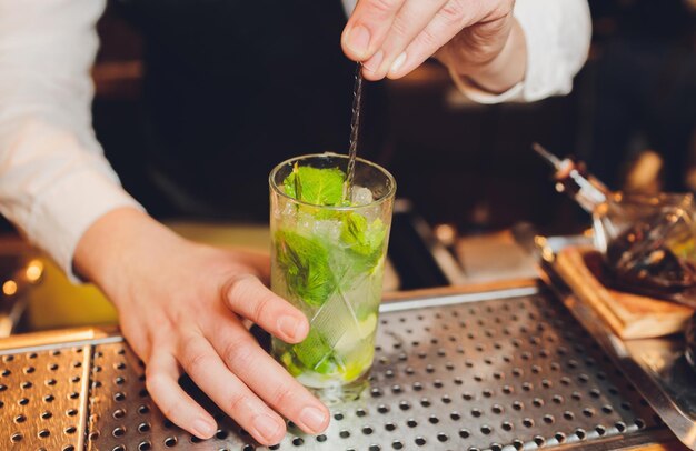 De barman maakt een cocktail op de bar in het restaurant.