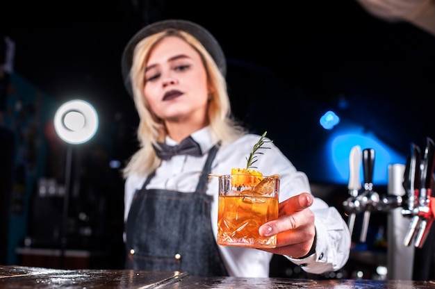 De barman van het meisje maakt een cocktail in de brasserie