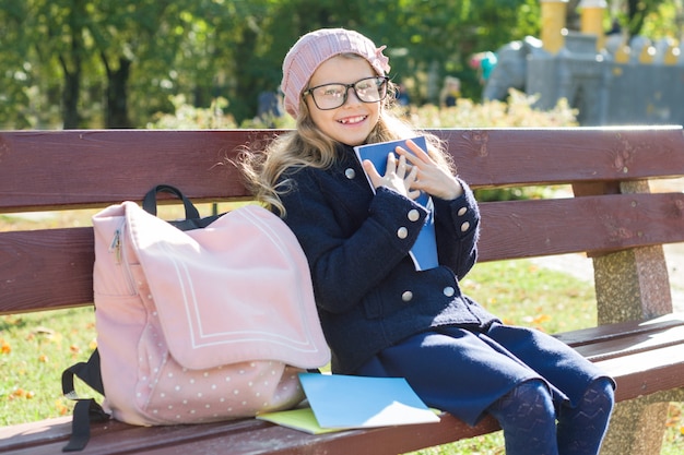 De basisschoolstudentzitting van het meisje op bank