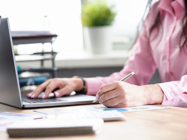 De beambte schrijft nota's en drukt op laptop