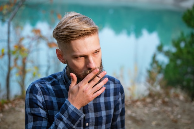 De bebaarde man rookt knappe stijlvolle man in geruit hemd met nicotineverslaving en slechte...