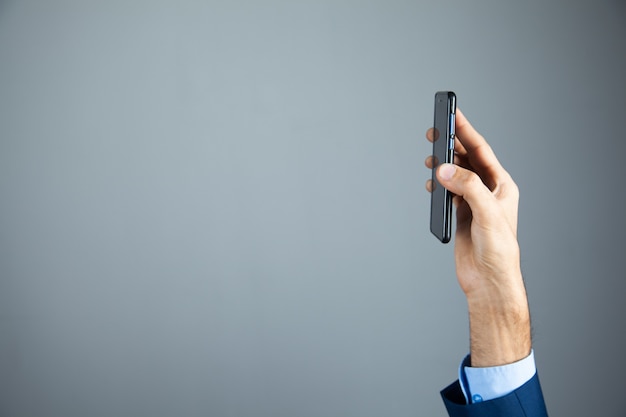 De bedrijfsmens toont telefoon in zijn hand