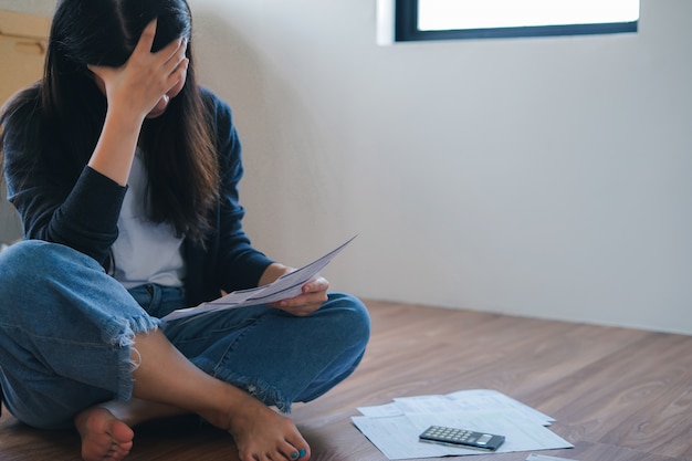 De beklemtoonde jonge aziatische vrouw ontmoet financieel probleem en creditcardschuld zonder terug te betalen geld.