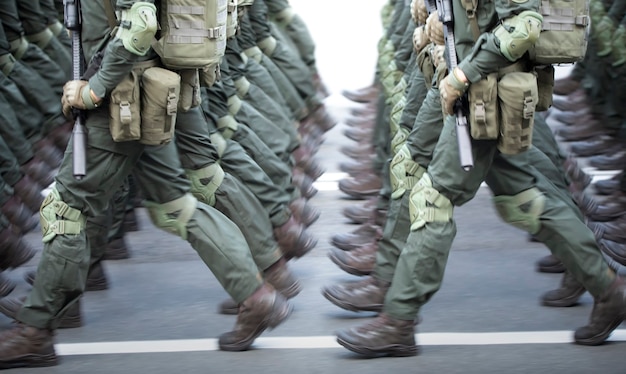 De benen van de soldaten zijn gekleed in enkellaarzen en camouflagebroeken.