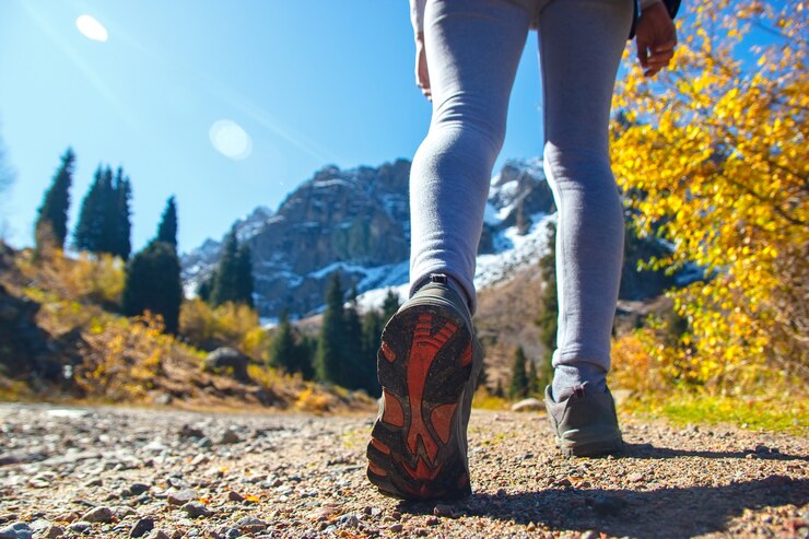 Foto de benen van een sportman in schoenen op een bergweg. dames sneakers.
