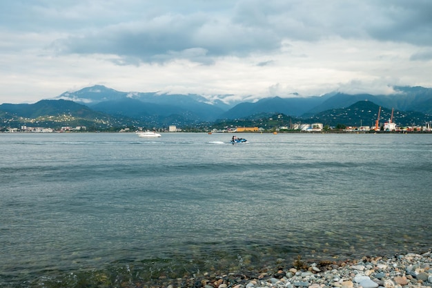 De bergen aan de kust in de verte kleine schepen en jachten