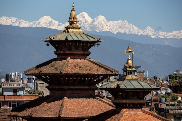 De bergen liggen achter de daken van Kathmandu