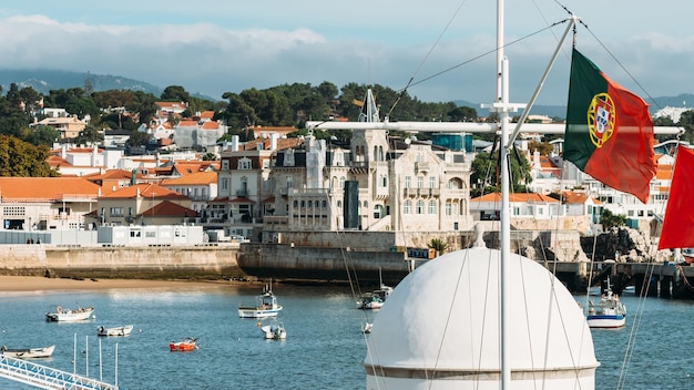 De beroemde baai van Cascais in Portugal met de Portugese vlag op de voorgrond