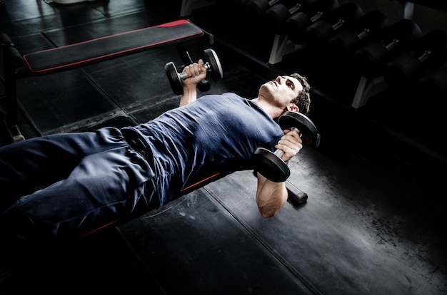 De bestelwagen van de mens dumbell in gymnastiek. oefening met work-out programma voor gezond