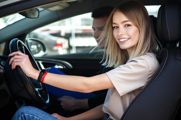 De bestuurder is een autoschoolinstructeur en een vrouwelijke student op een examenauto