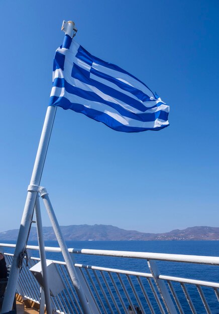 De blauw-witte Griekse vlag waait tegen de blauwe hemel.